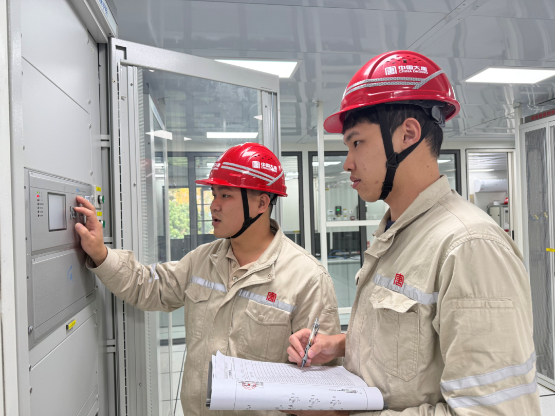 钦北大直光伏项目并网前运维人员正对设继电保护柜进行检查并记录数据（黄春香摄）.png