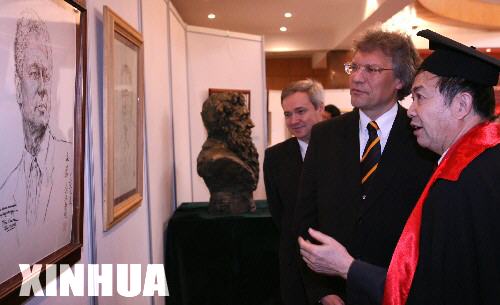 2月15日，著名艺术家袁熙坤（右）向俄罗斯驻华大使拉佐夫（中）介绍自己的作品。